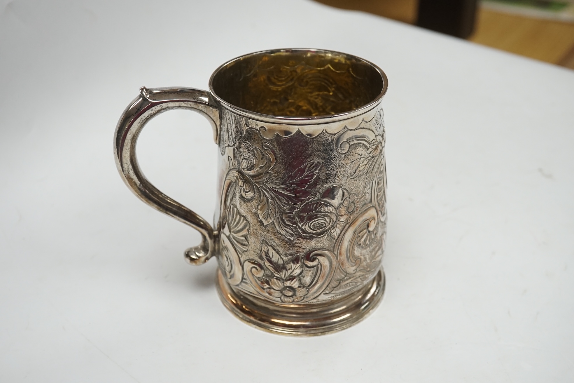 A George II silver mug, with later embossed decoration, Thomas Rush, London, 1733, 11.5cm, 11.9oz. Condition - fair to good